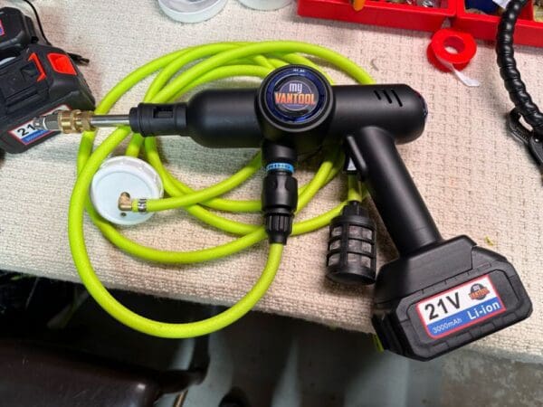 A green hose and a black electric drill