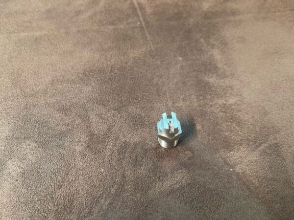 A small blue object sitting on top of a brown carpet.