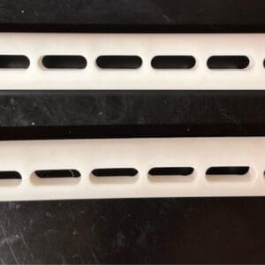 Two pieces of VANTOOL 12" Hybrid Slotted Glide G2 [8mm] with holes in them.