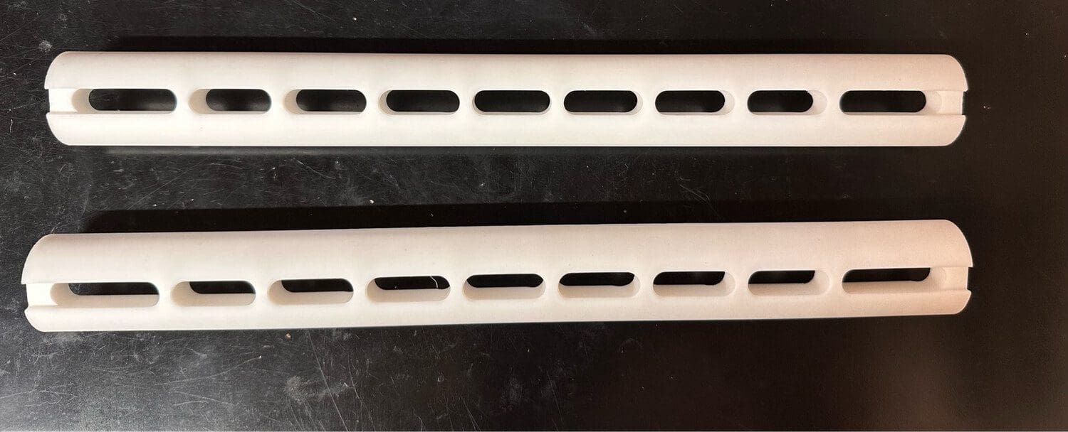 Two pieces of VANTOOL 12" Hybrid Slotted Glide G2 [8mm] with holes in them.