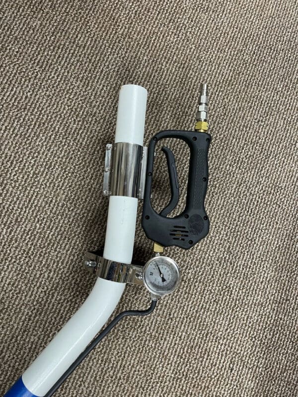 Pressure gauge and spray gun on a hose.