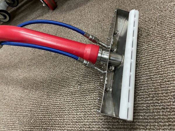 Red and silver carpet cleaning tool.