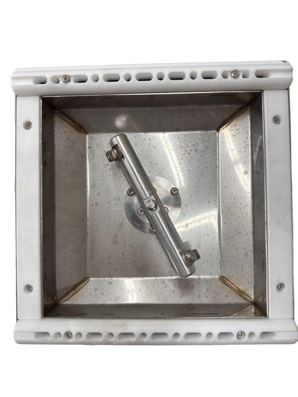 Stainless steel square pan with metal rod.