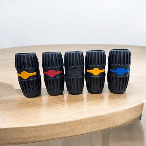 Five colorful cylindrical rubber items on table.