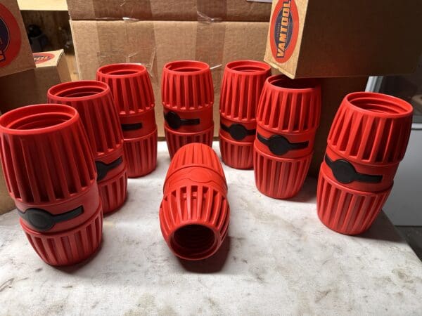 Red plastic pipe connectors on table.