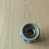Gray bottle cap on wooden surface.